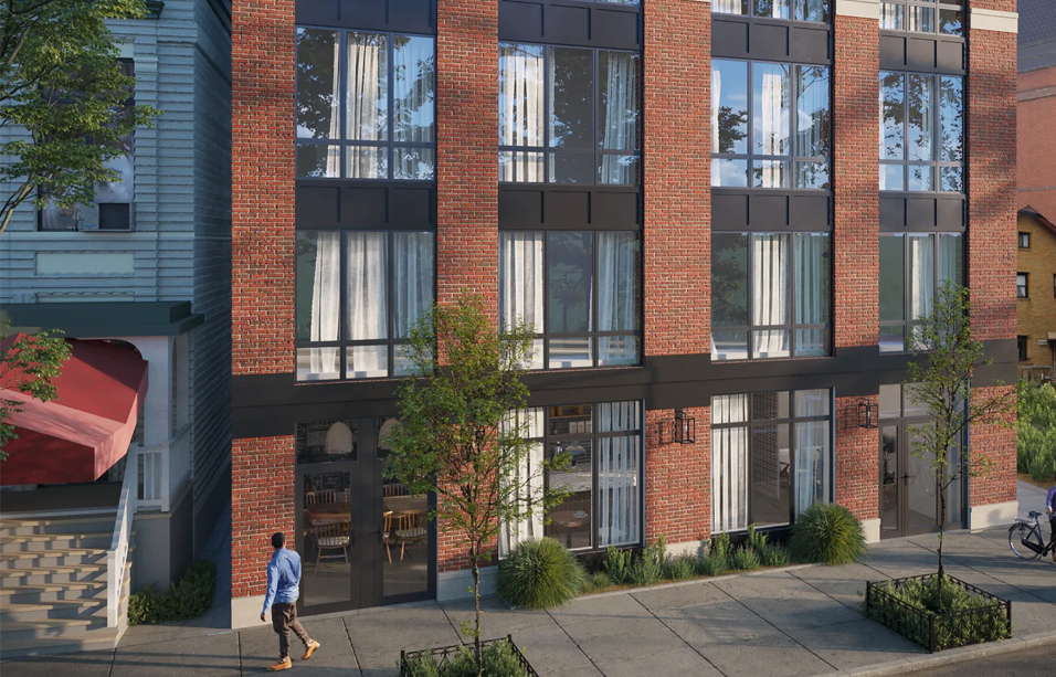 Red brick apartment building with large windows and glass storefronts on a tree-lined sidewalk, with a man walking past